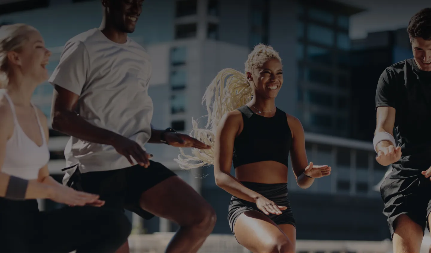 People smiling during an outdoor group fitness workout in the city
