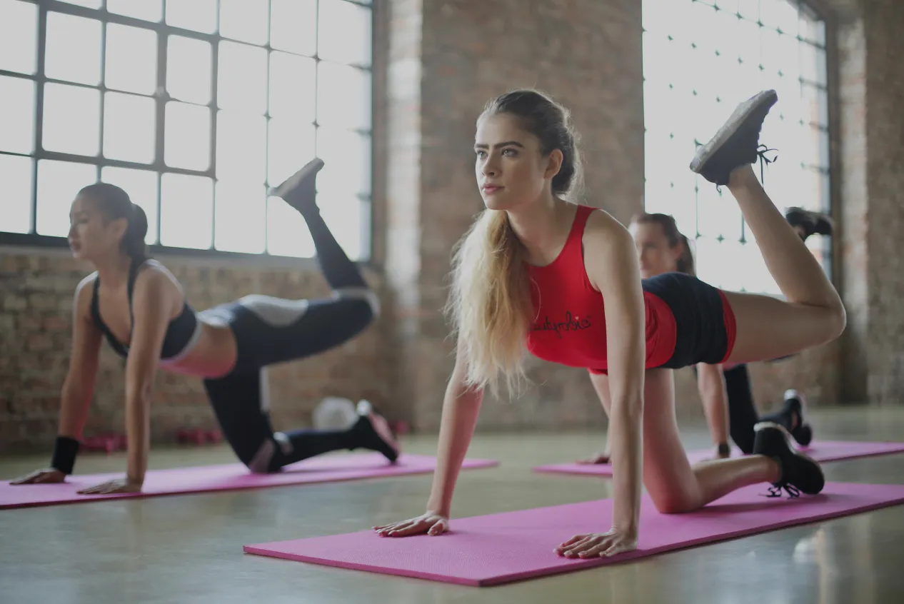 Group of women doing floor exercises in a bright fitness studio